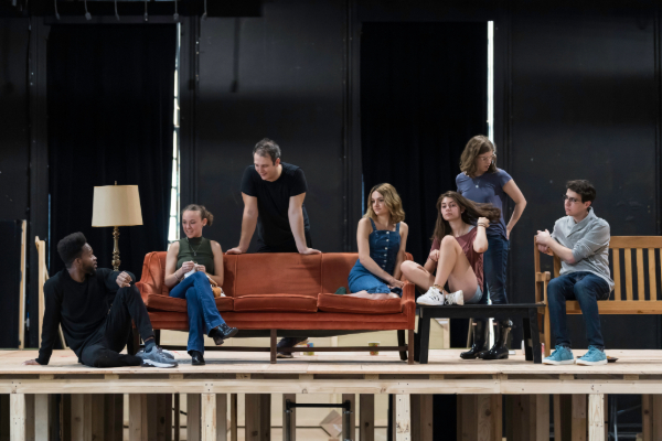 A still shot of students acting in a play on stage.