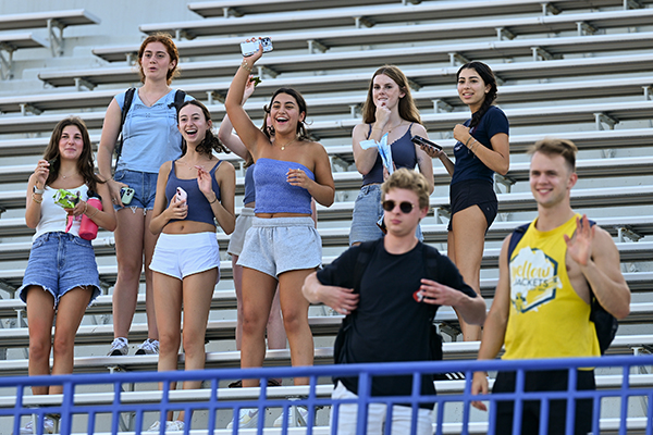 A group of students cheering from the stands.